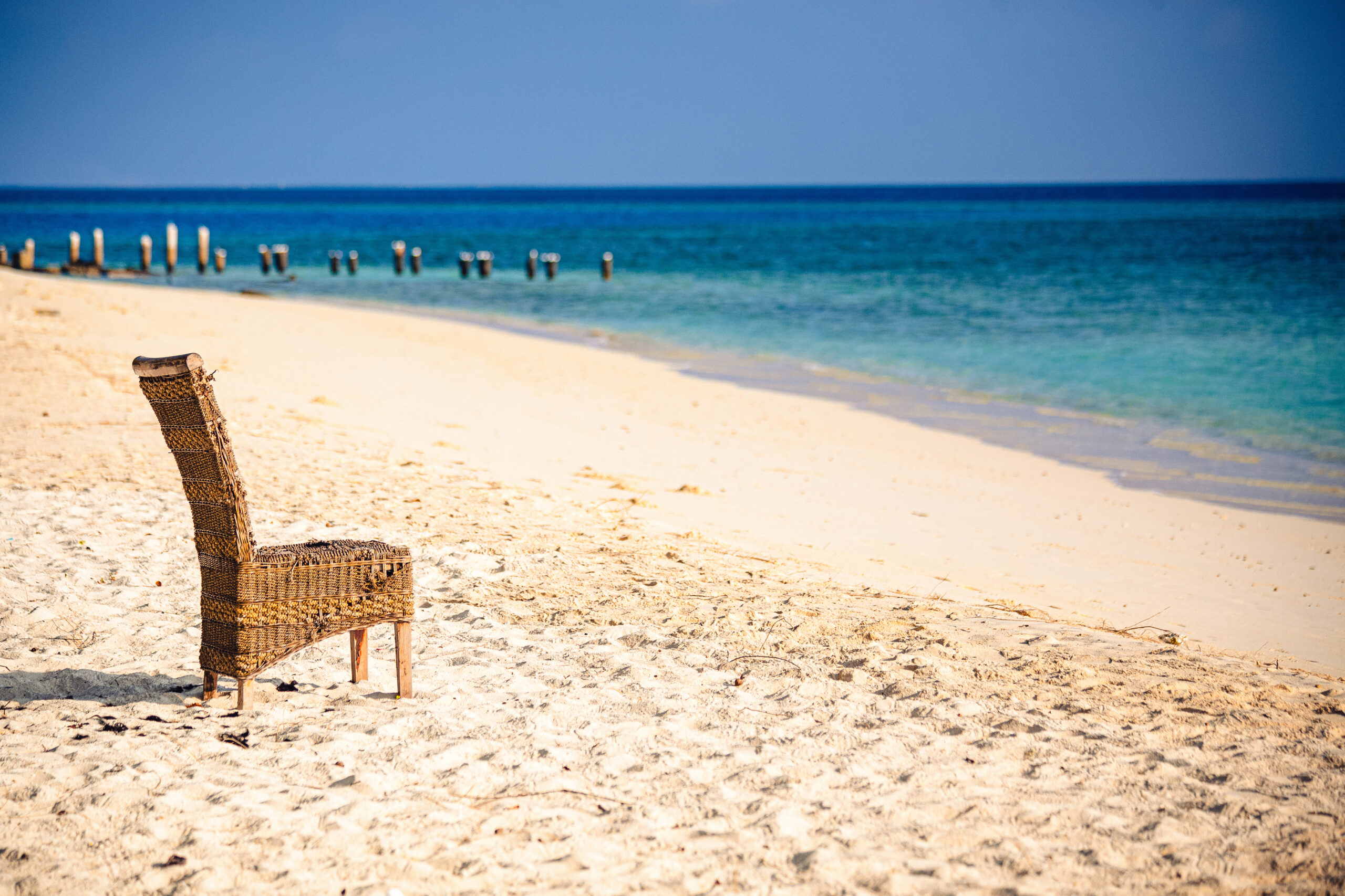 A quiet chair on a white sand beach