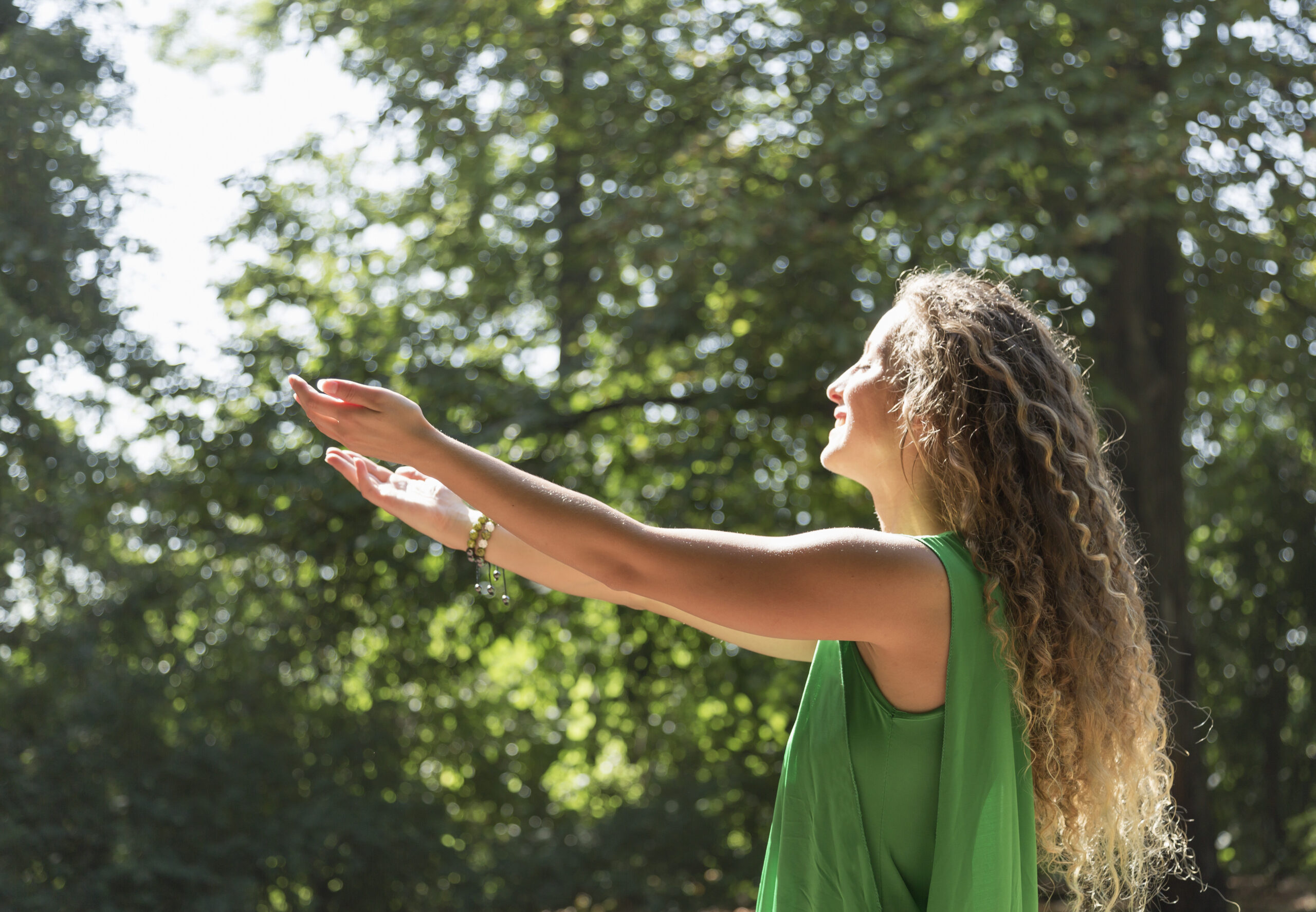 Young woman with arms outstretched facing the sun — embodying the freedom, energy, and clear focus that ADHD-friendly attention practices can support