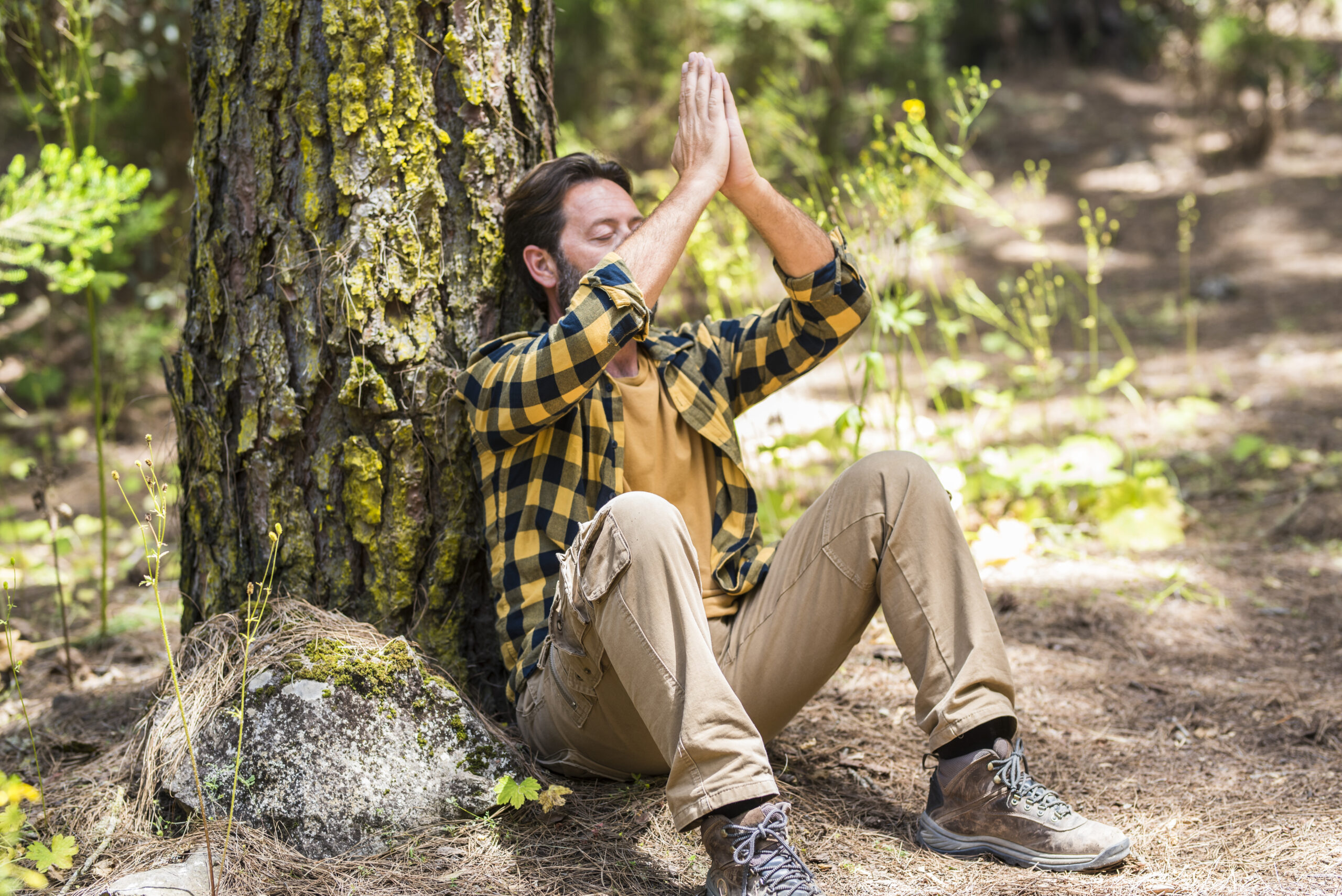 Adult sitting peacefully in a sunlit forest practicing quiet meditation — natural morning sunlight, circadian rhythm regulation, and calming the ADHD nervous system