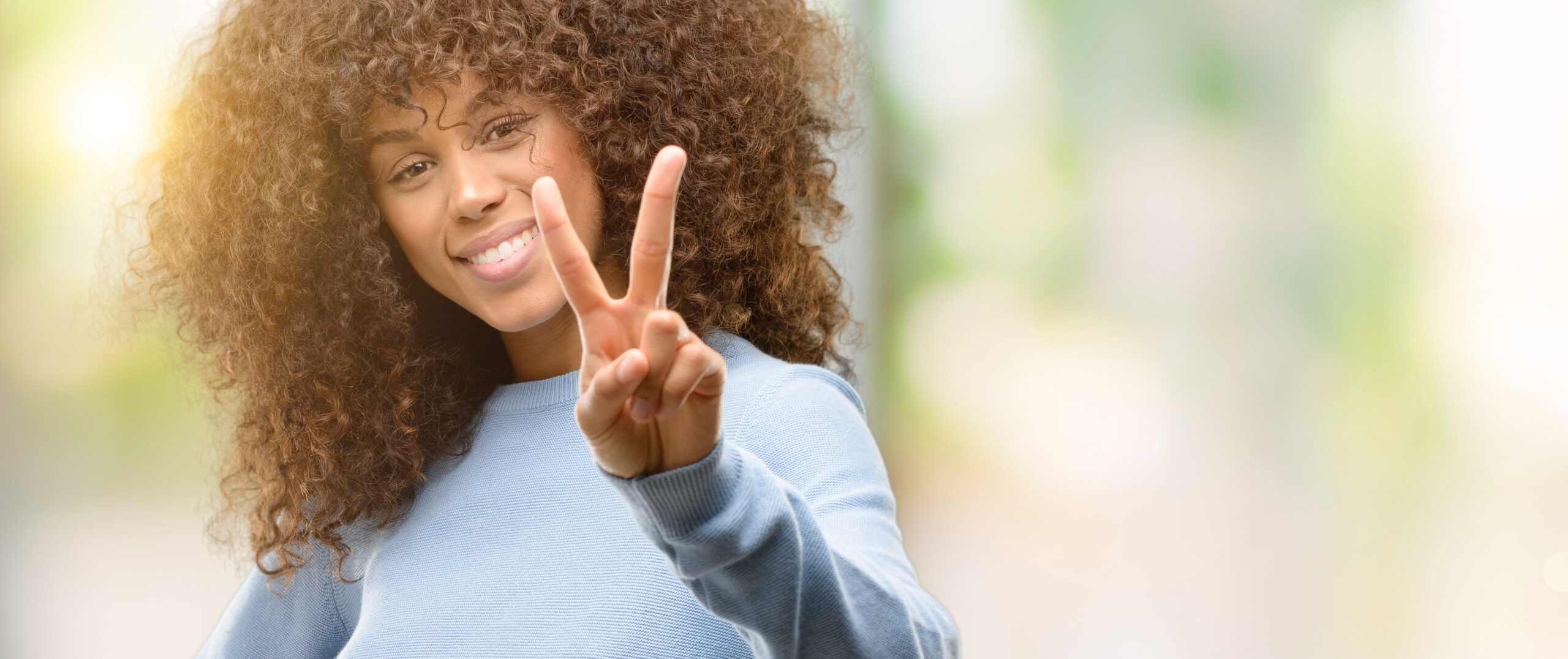 Joyful adult smiling in warm sunlight — welcoming ADHD support for individuals, families, and communities of all backgrounds at Orchard Human Services