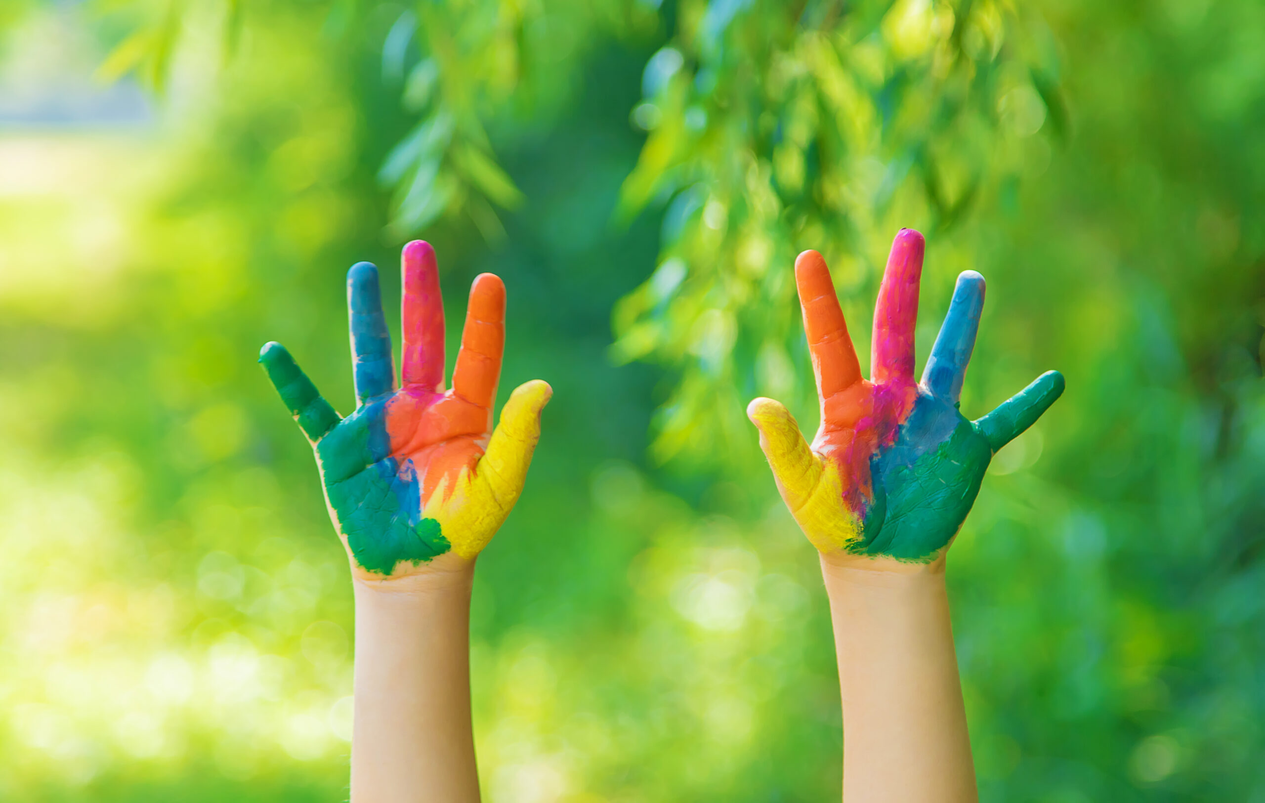 A child with brightly painted hands and legs