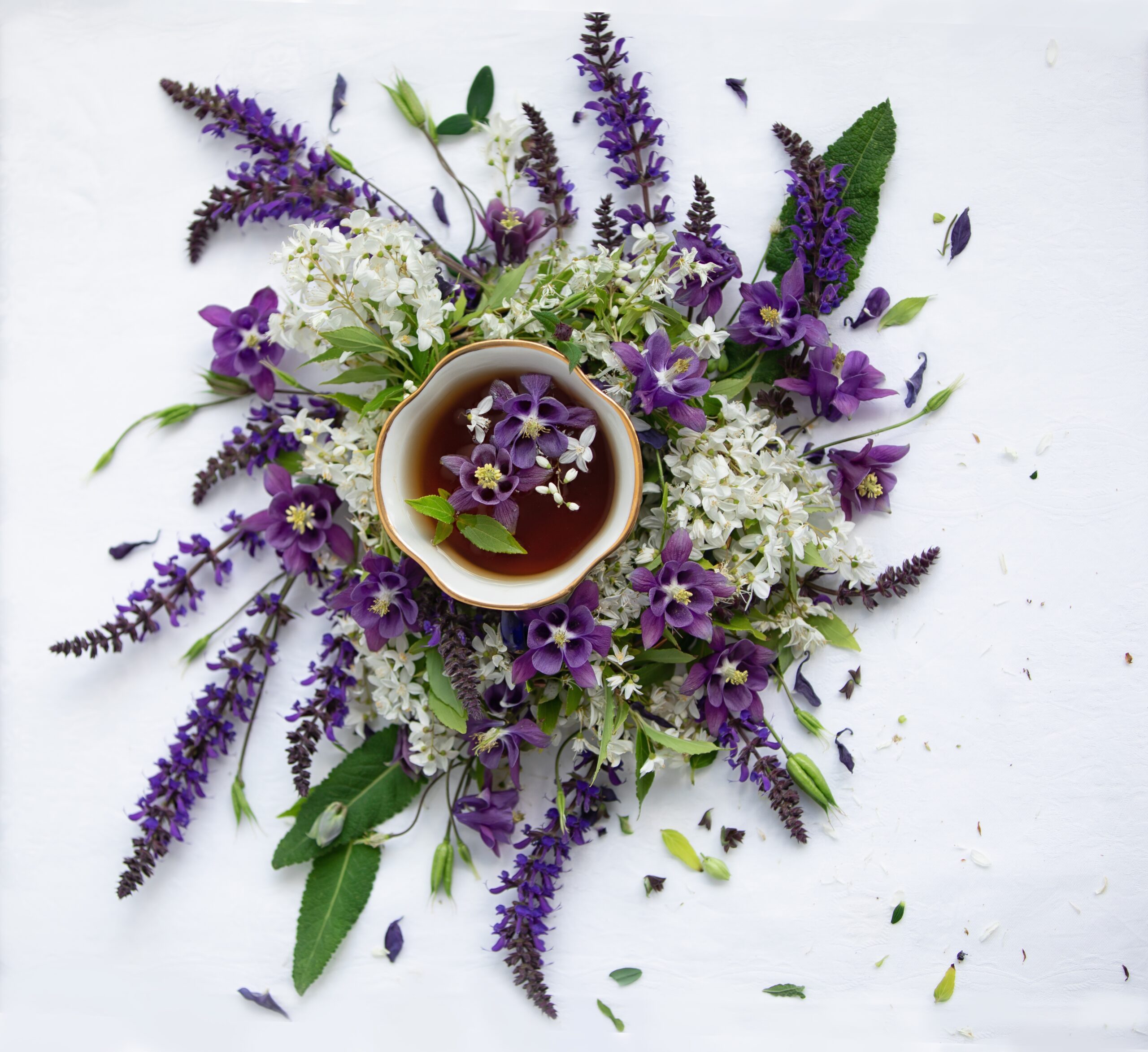 Cup of herbal tea surrounded by fresh flowers — mindful nourishment and whole-food practices sometimes discussed in ADHD literature