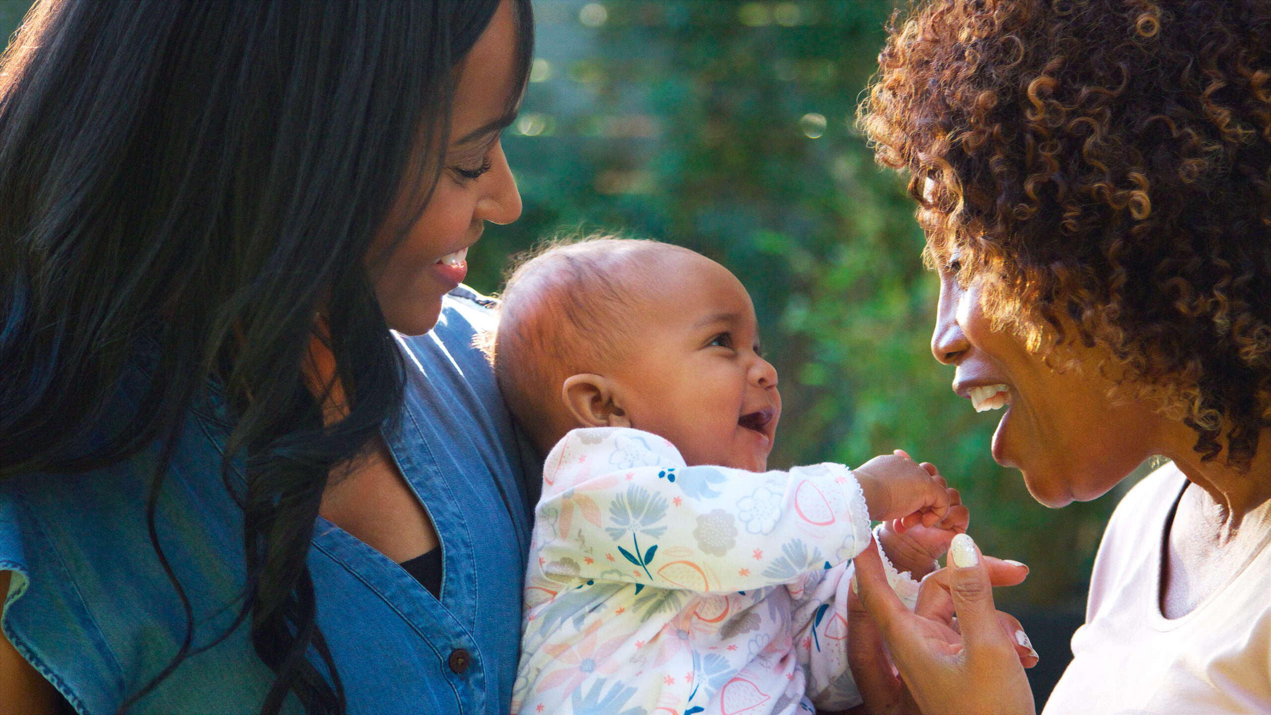 A grandmother, her adult daughter, and a baby granddaughter together