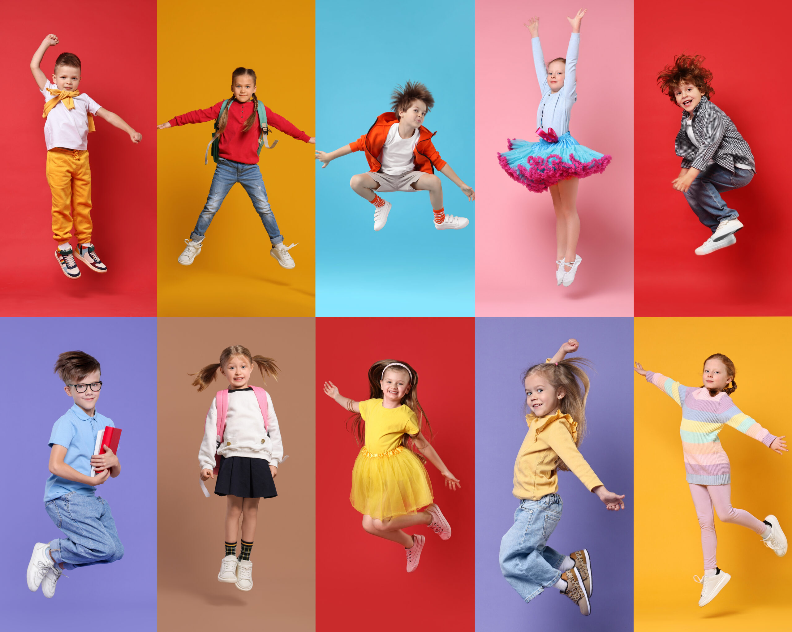 Happy children jumping together in a colorful studio