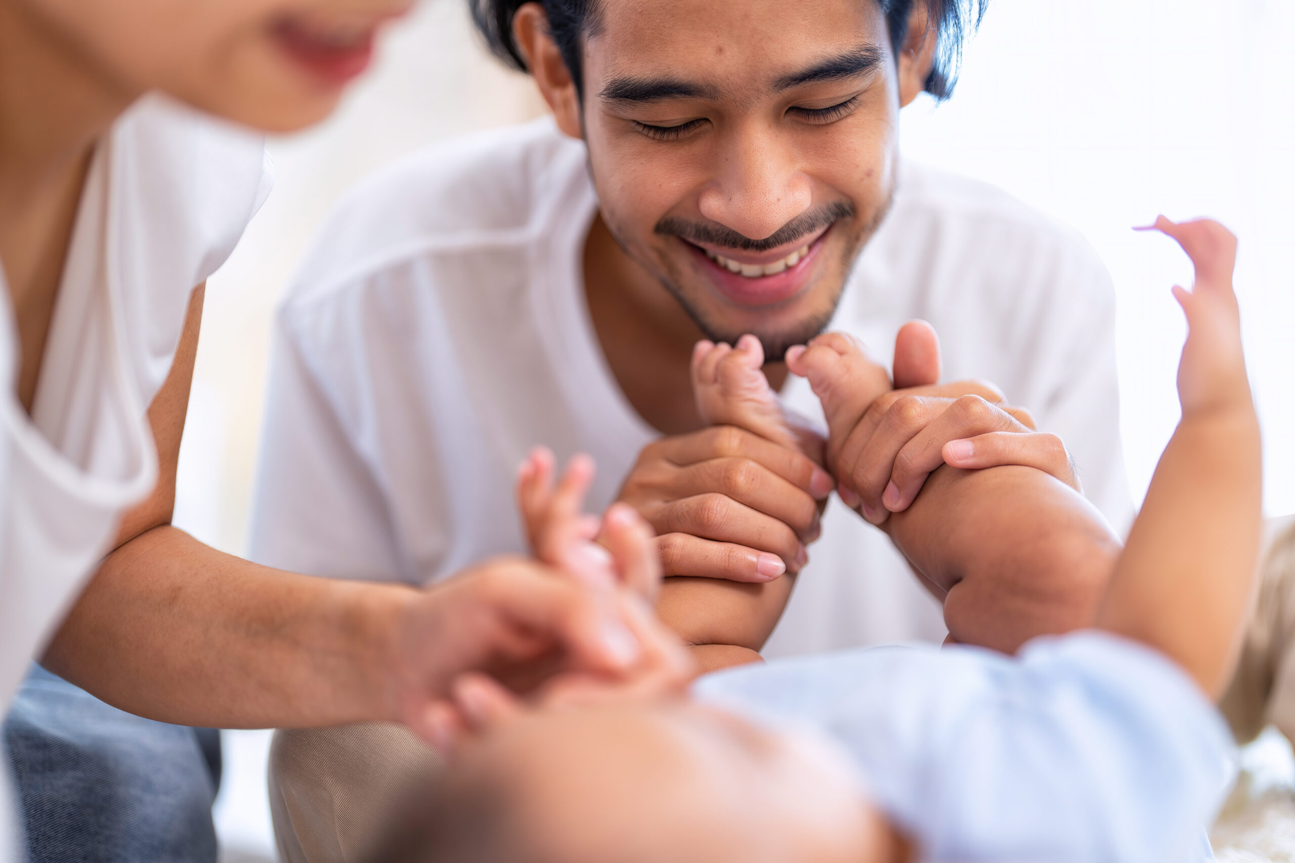 A happy father playing with his baby at home