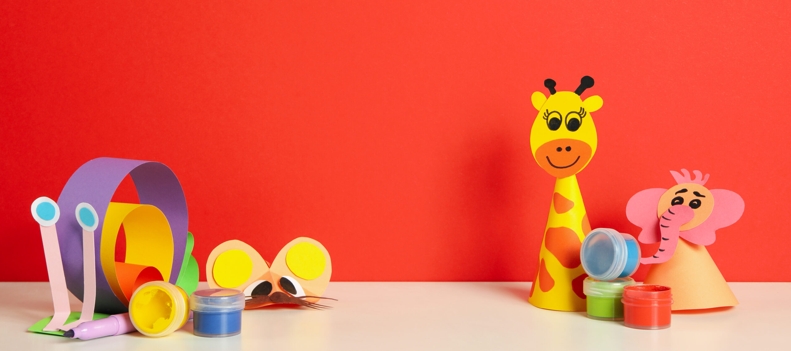 Paper animal crafts and paints on a red background