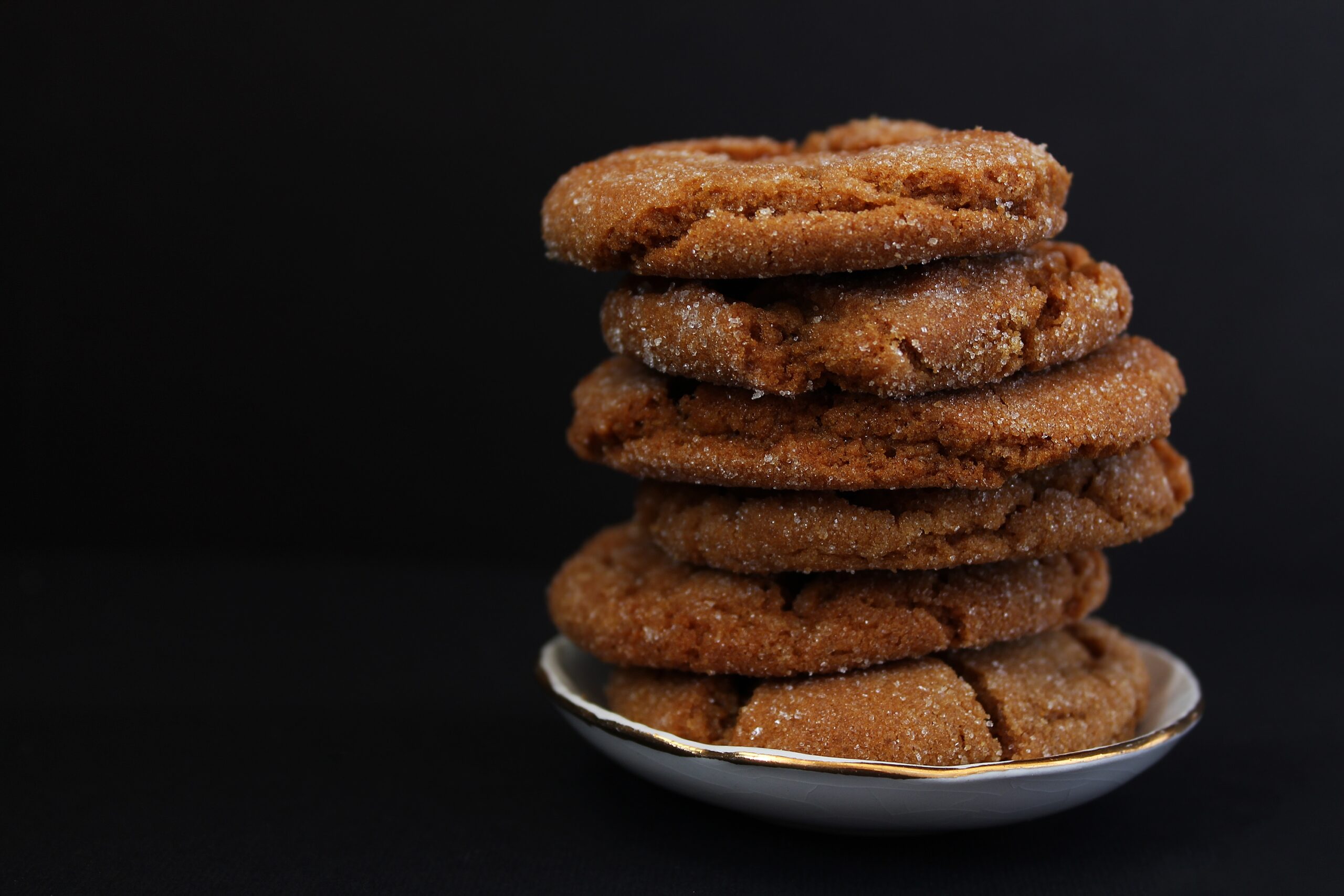 A stack of warm molasses ginger crinkle cookies on a plate