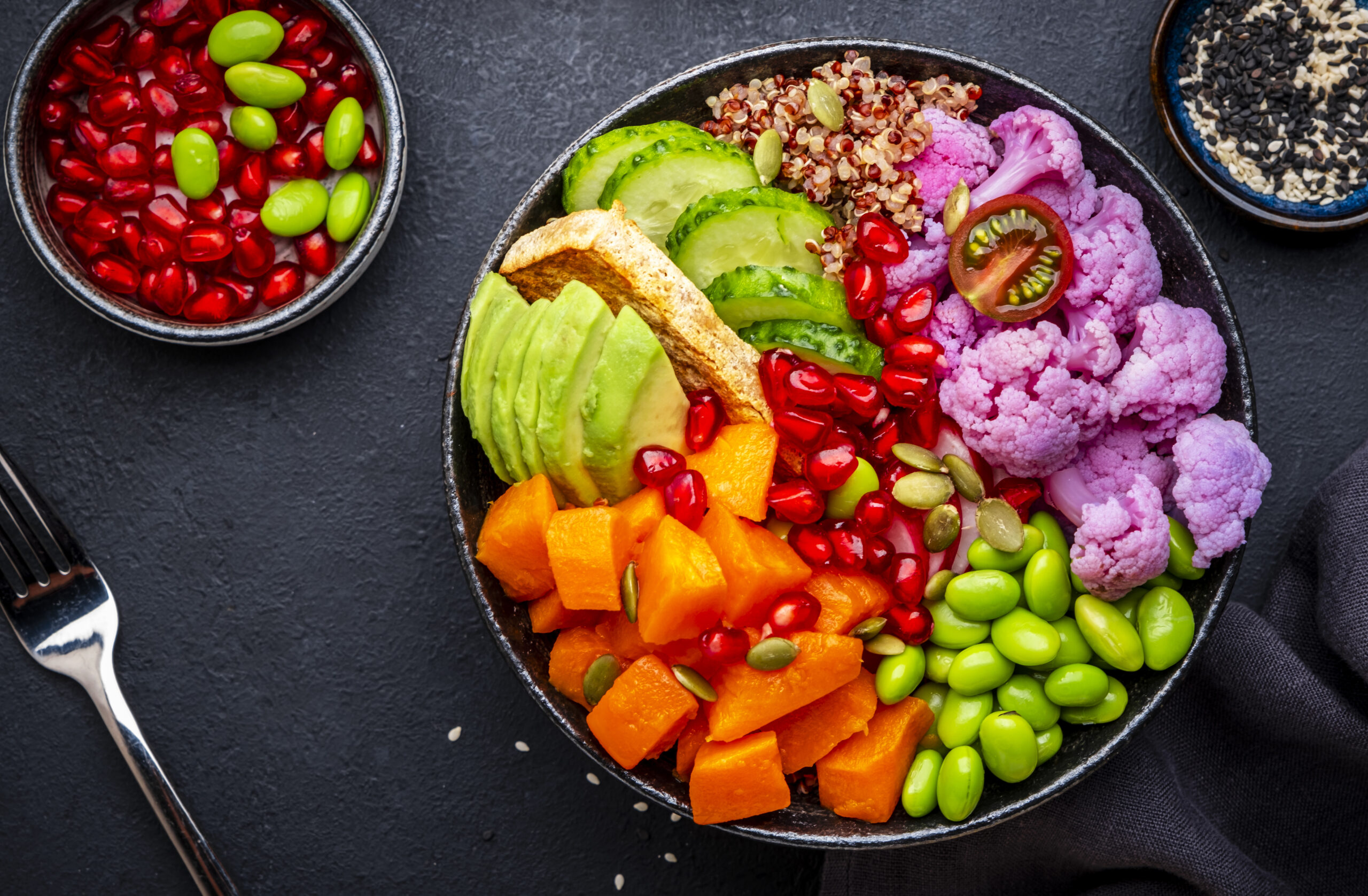 A bowl of brightly coloured fresh vegetables and salad ingredients.