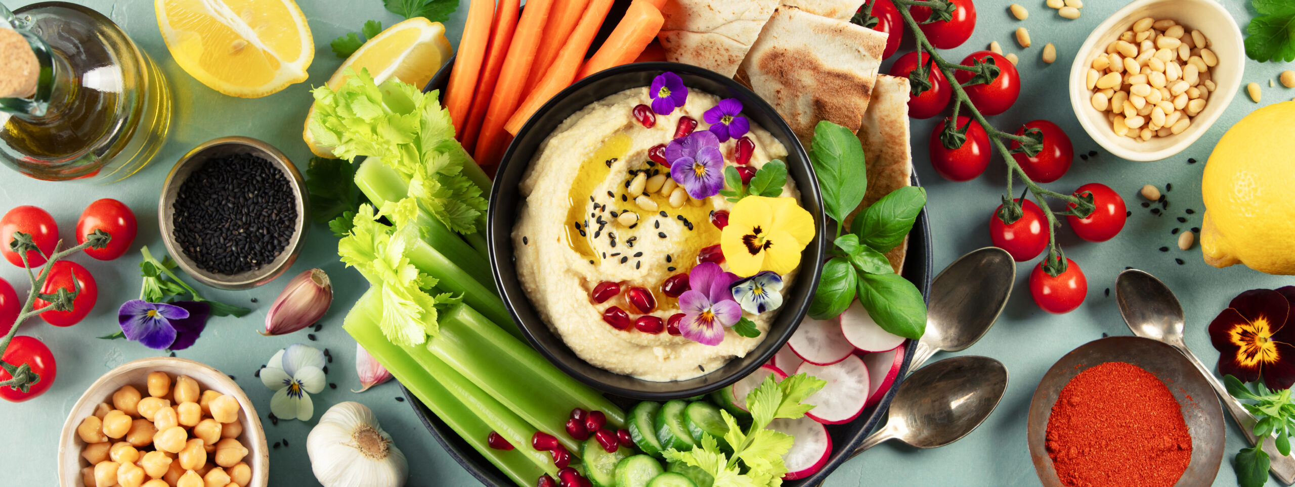 Hummus with fresh vegetables and pita bread.