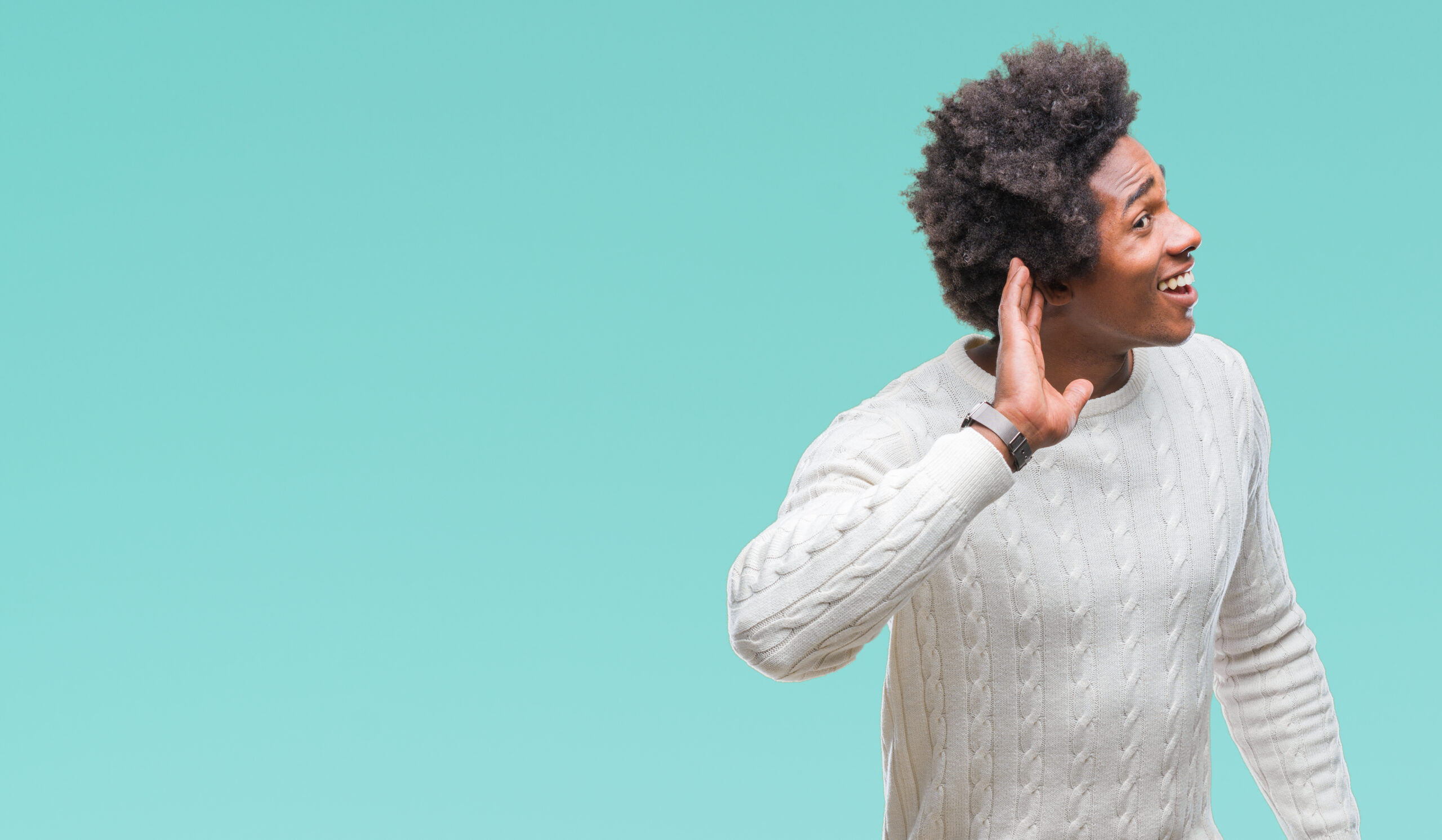 A man cupping his hand to his ear, listening intently.