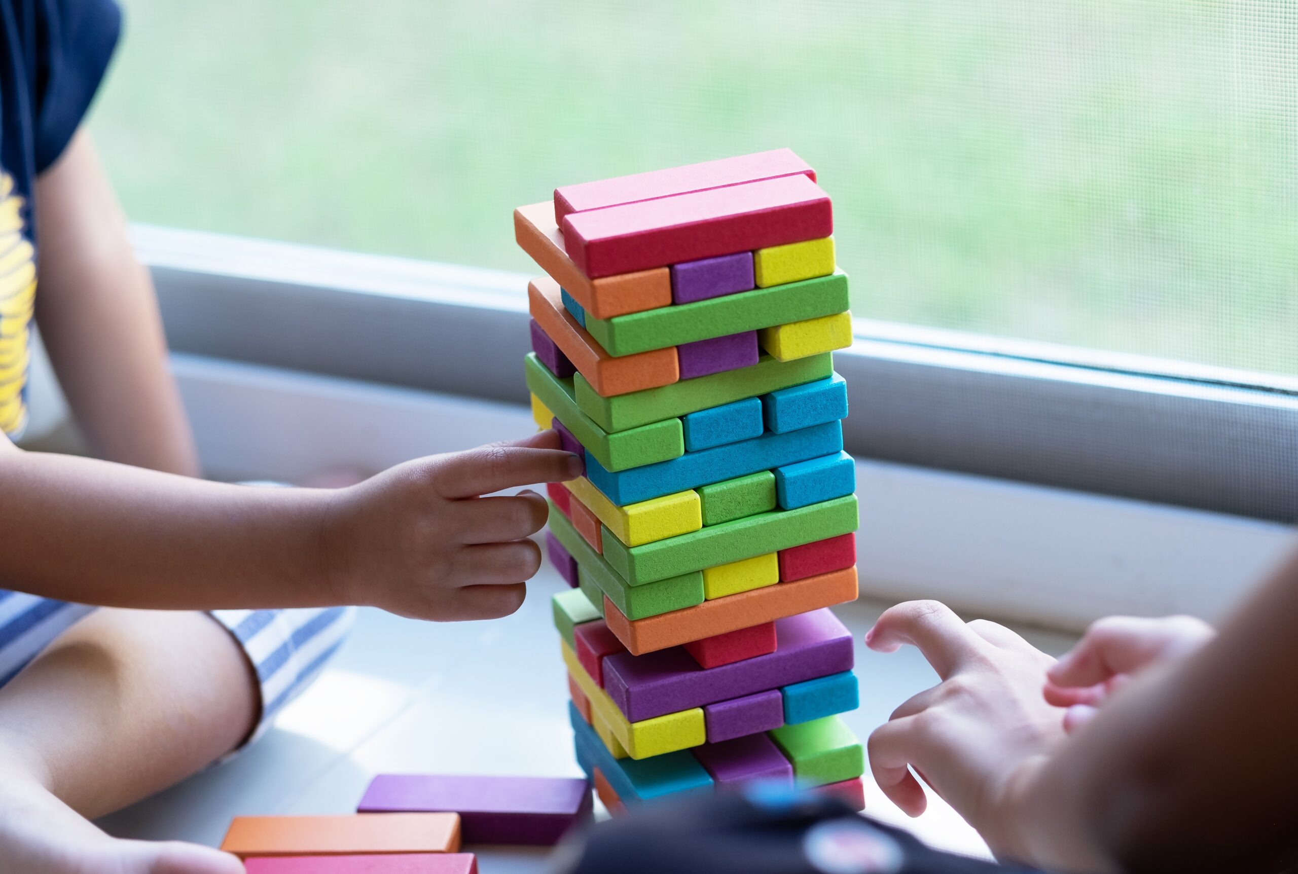 Children playing together with colourful wooden blocks