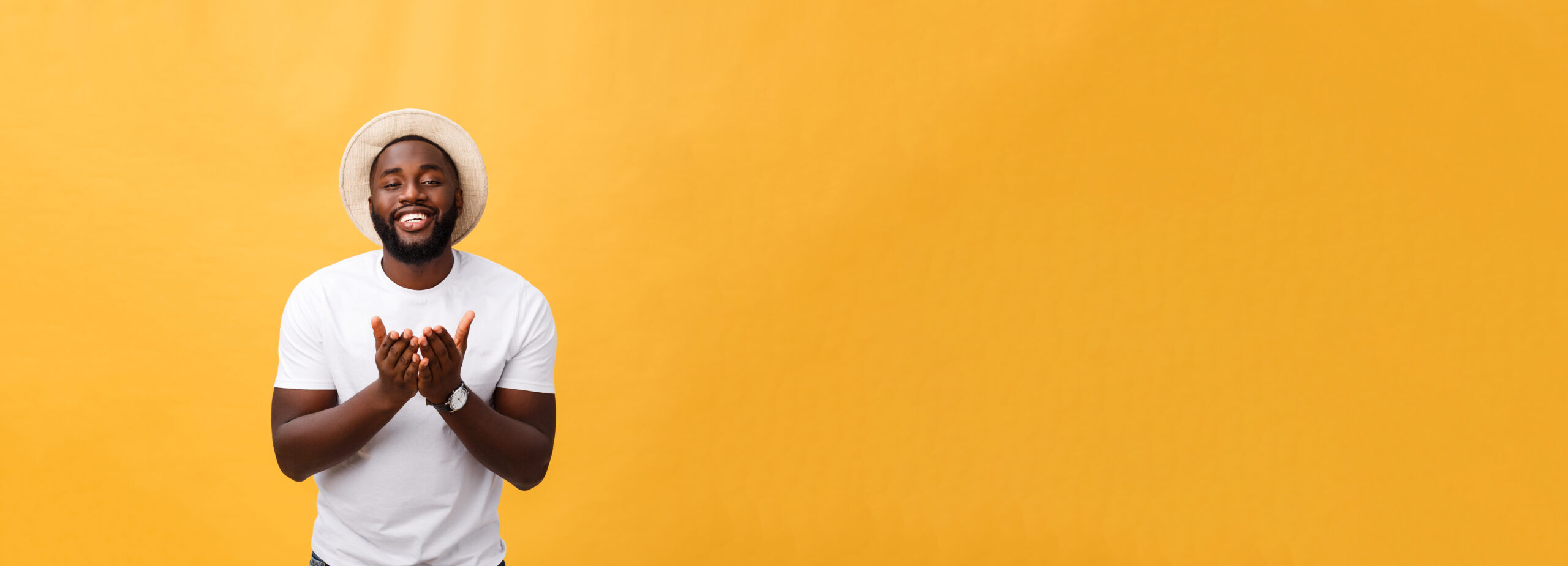 Smiling man in front of a yellow wall