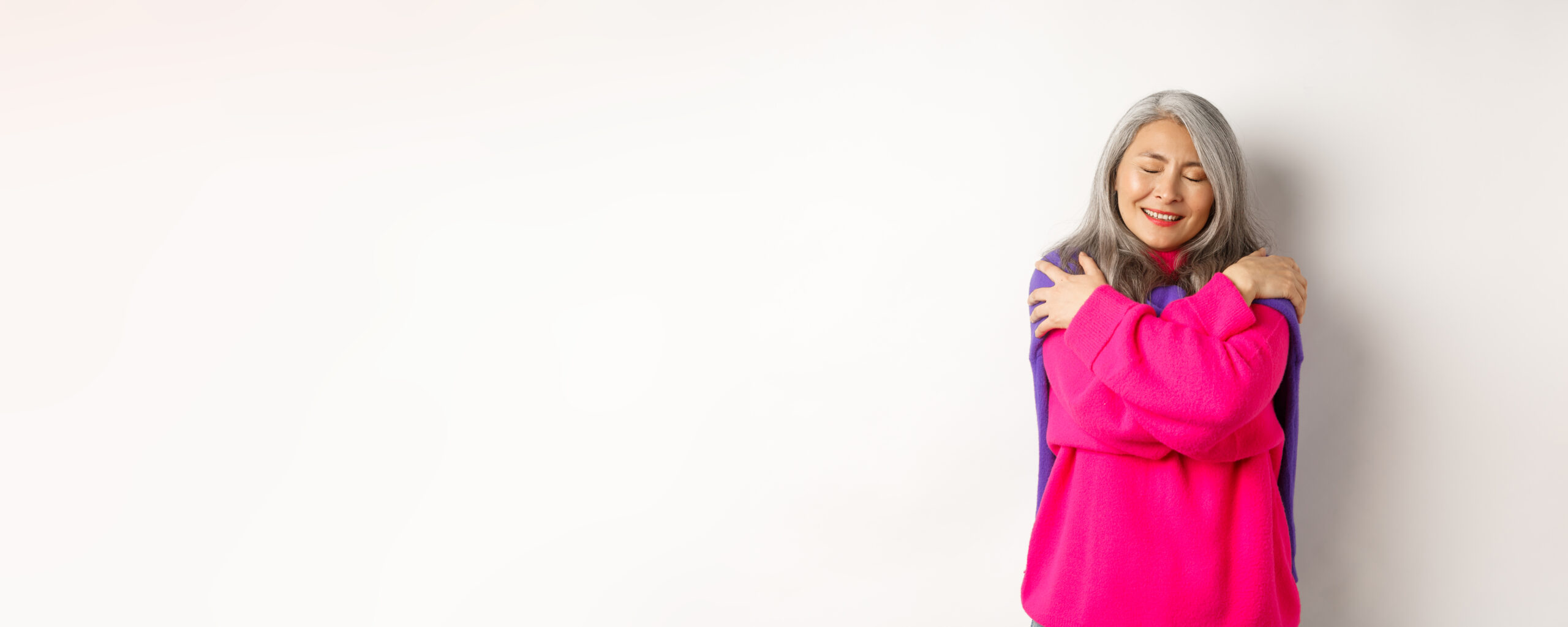 Woman embracing herself with eyes closed, calm